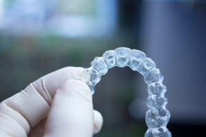 A hand holding a dental clear brace