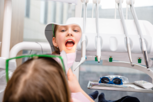 A child looking at her mouth in a mirror