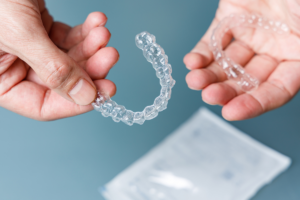 The hands holding a clear dental aligners