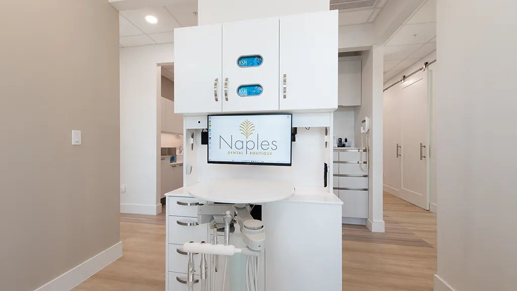 Modern dental station with naples dental boutique logo on monitor